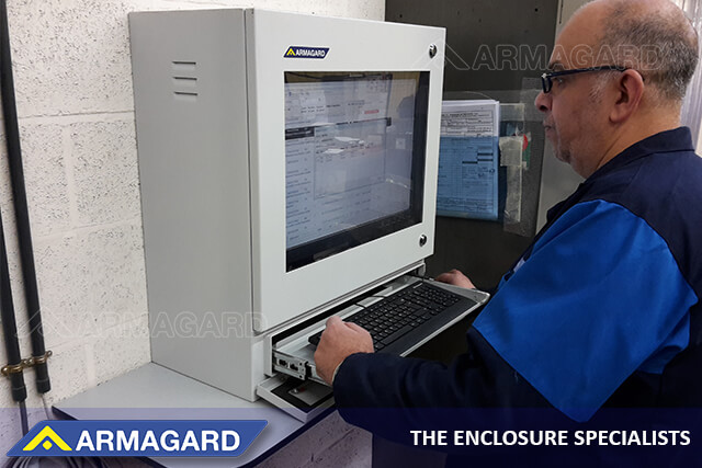 En industriel medarbejder, der bruger en IP54 PC-arbejdsstation til produktionsgulvet